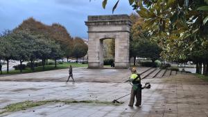 Un operario limpiando de hierbas el pavimento de Porta Nova