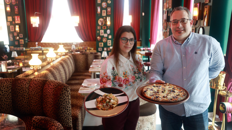 Xabier Lago, propietario del local, posa junto a una trabajadora en el espacio único de la calle Fernando Macías, junto a una de las pastas y una de las pizzas de la carta
