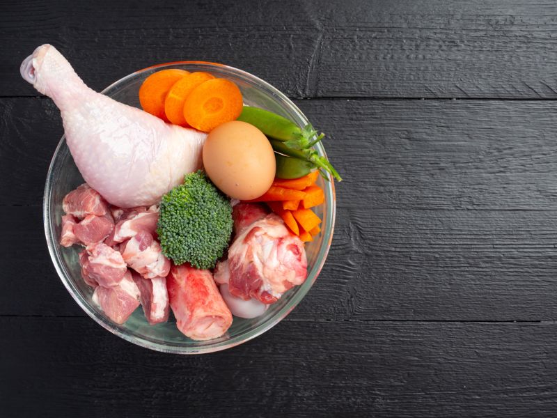 Ingredientes de alimentos para mascotas frescos y saludables en superficie oscura