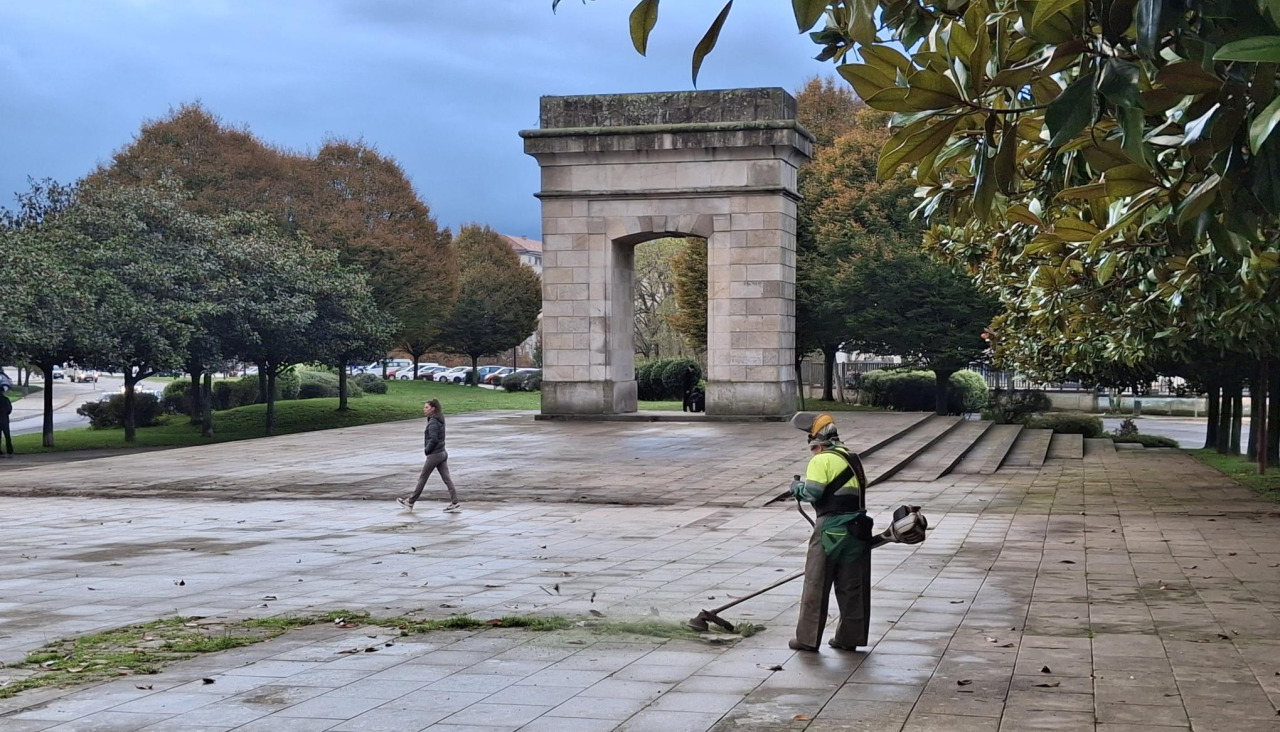 Un operario limpiando de hierbas el pavimento de Porta Nova