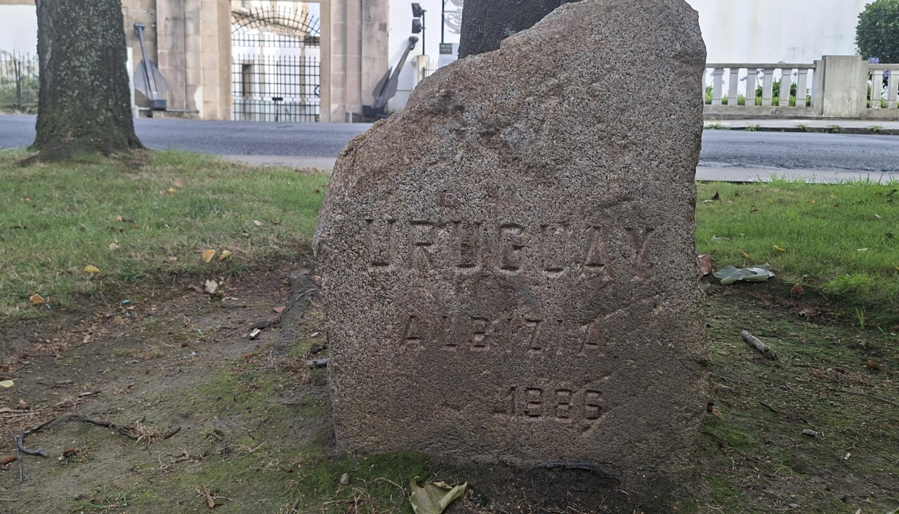 La piedra grabada para conmemorar la plantación de la acacia por parte de Uruguay
