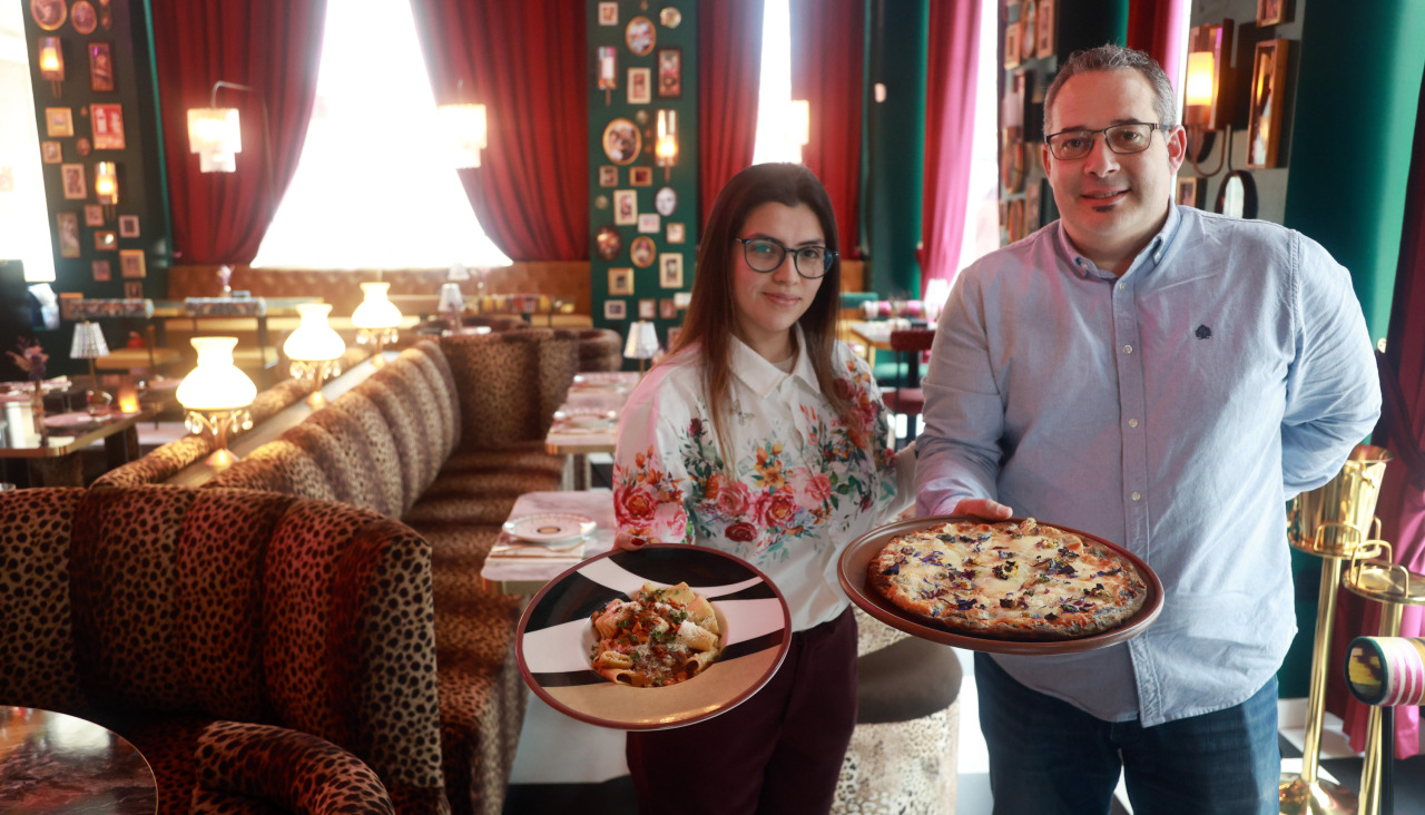 Xabier Lago, propietario del local, posa junto a una trabajadora en el espacio único de la calle Fernando Macías, junto a una de las pastas y una de las pizzas de la carta