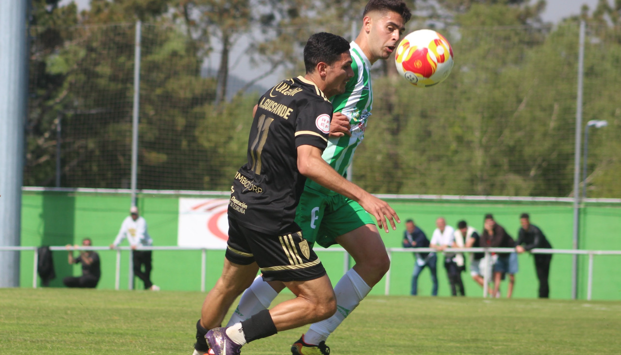 Óscar Varela lucha con un rival por llevarse la pelota