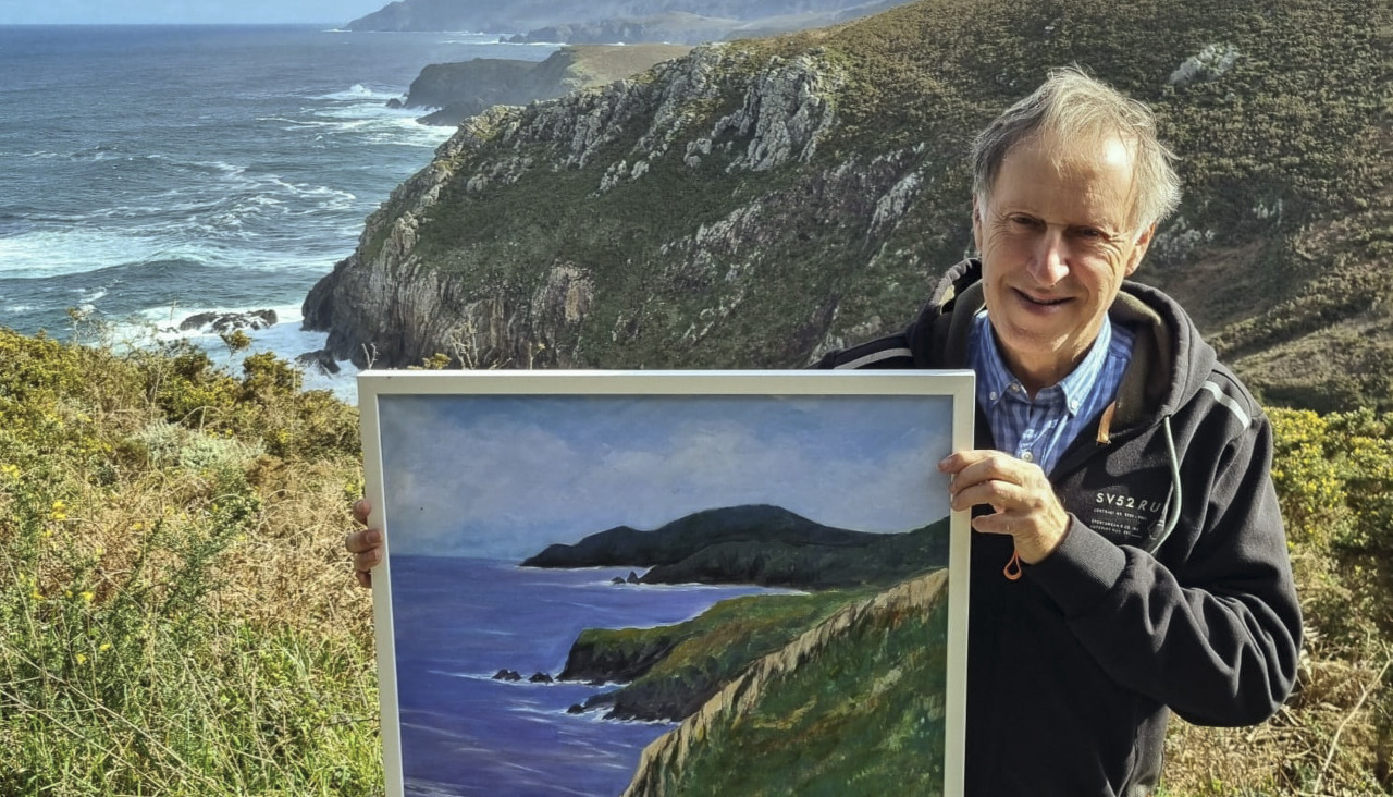 El artista exhibiendo uno de los paisajes con su interpretación