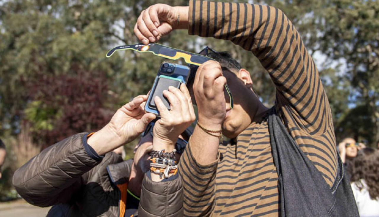 Dos personas observan un eclipse solar